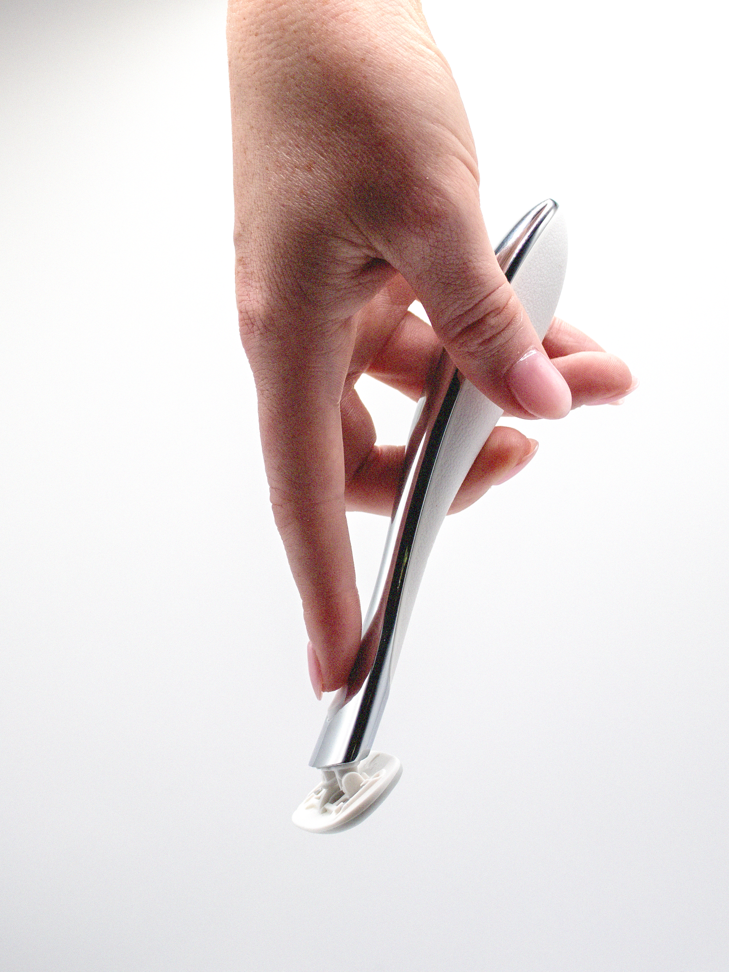 Hand holding a silver razor against a white background