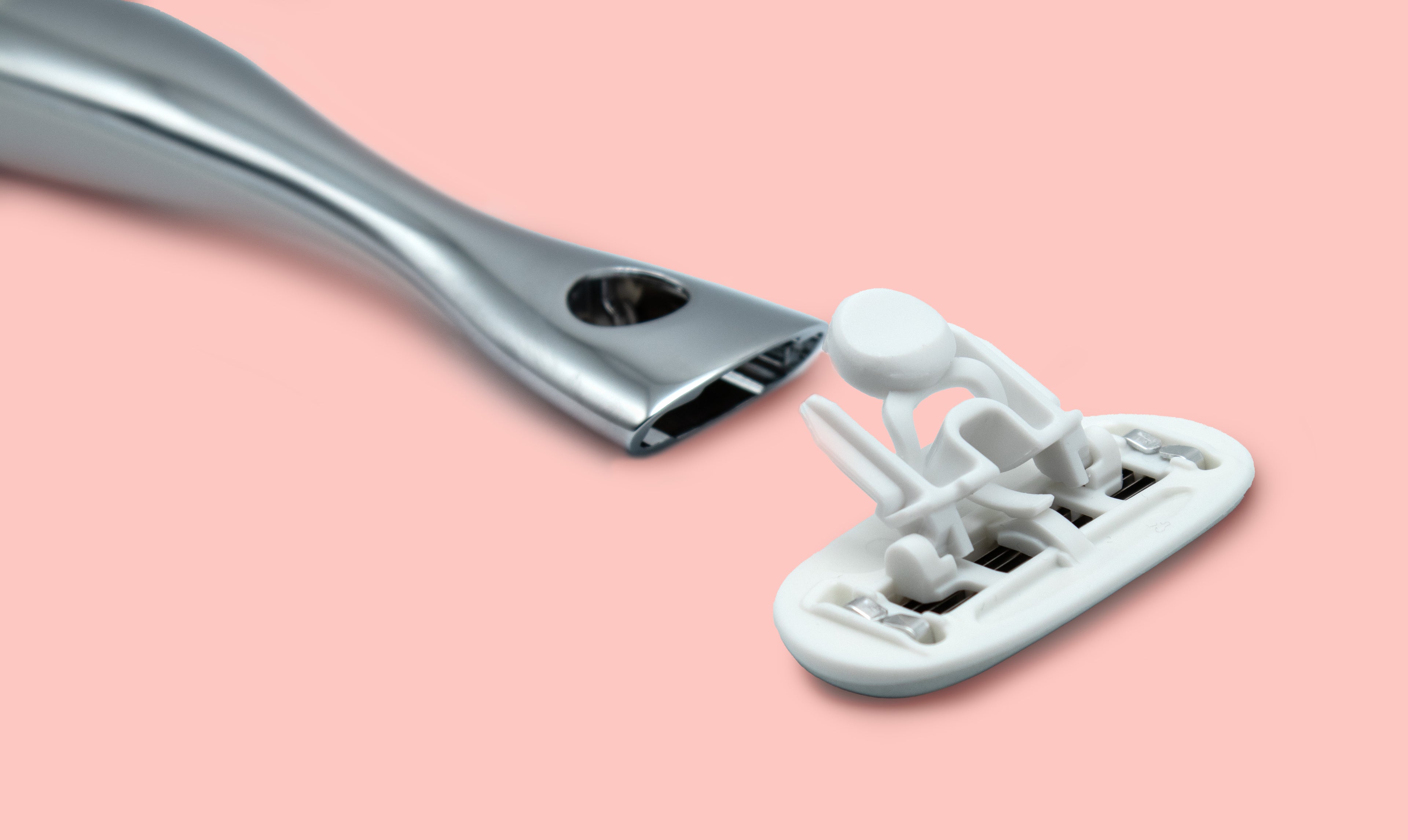 Razor cartridge to handle blade connection on pink background