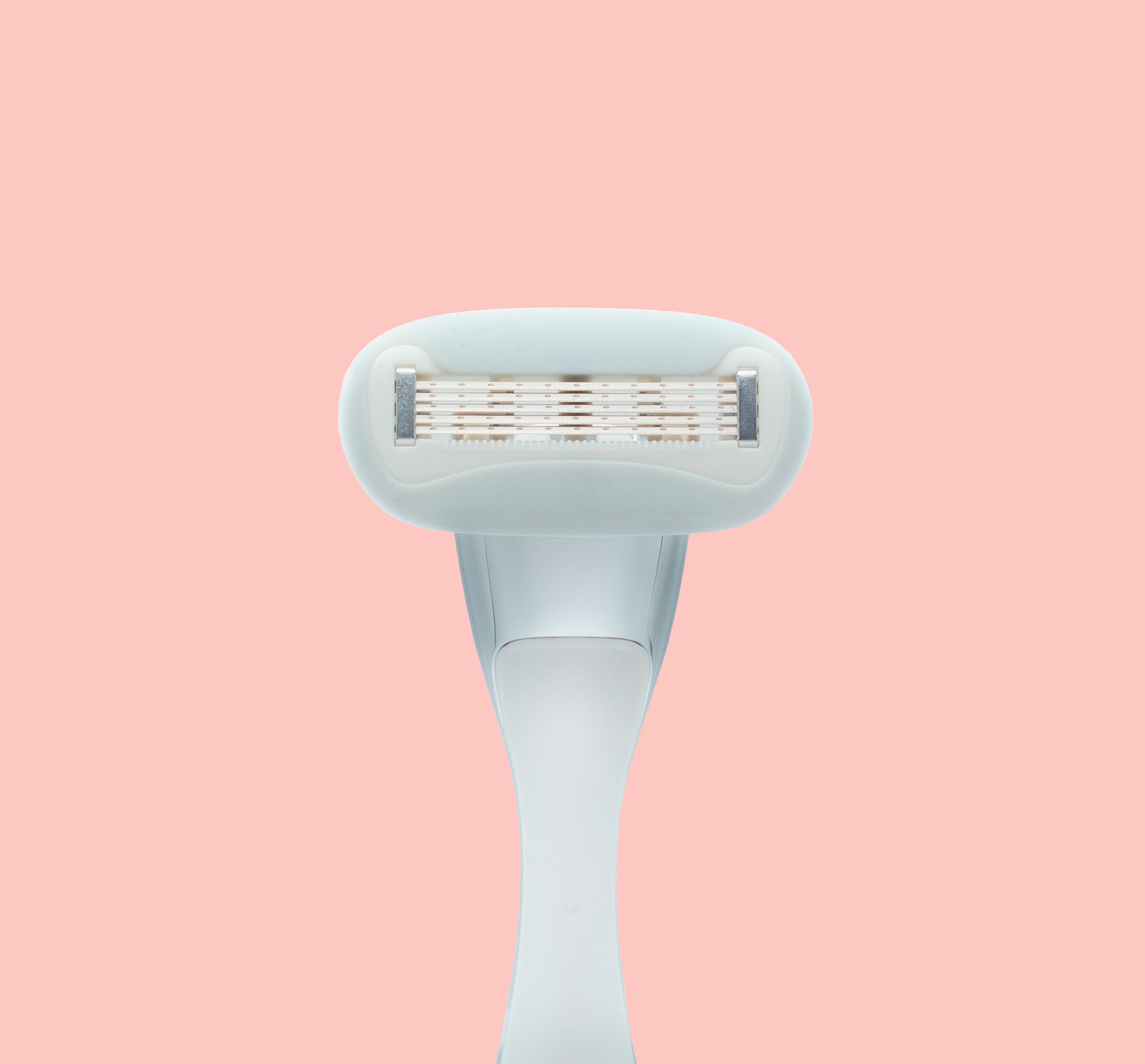 Underside of razor blade cartridge on pink background